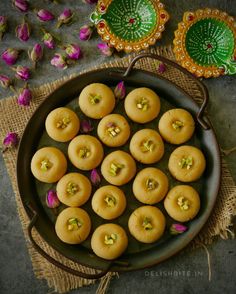 some food is sitting in a pan on a table next to flowers and decorative plates