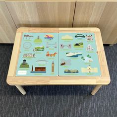 a wooden table with pictures on it in front of a cabinet and carpeted floor