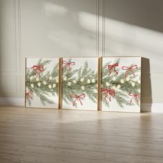 three canvases with christmas decorations on them sitting on the floor in front of a wall