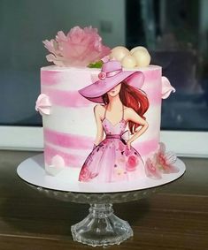 a pink and white cake with a girl on it