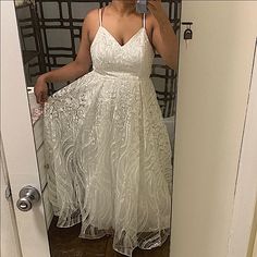 a woman in a white dress taking a selfie