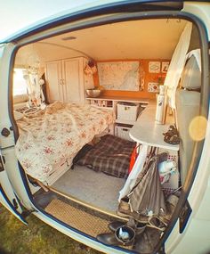 an image of a bedroom in the back of a van that is parked on grass