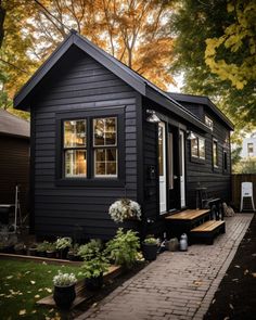 a small black house sitting on top of a lush green field