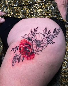 a woman's thigh with flowers and leaves on it