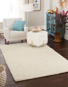 a living room with a white rug and blue accents