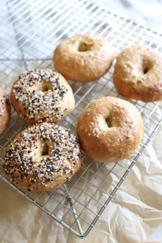 six bagels on a cooling rack with sprinkles and black sesame seeds