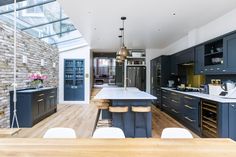 a kitchen with blue cabinets and an island in the middle is seen from across the room