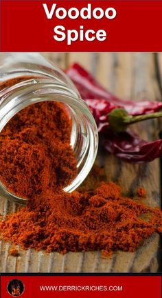 a glass jar filled with red spice next to peppers on top of a wooden table