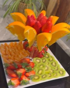 a plate with strawberries, oranges and other fruit on it