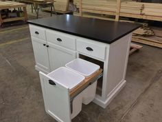 a kitchen island with two bins under it