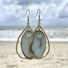 Unique oyster shell gold teardrop hoop earrings with round pearl. Small oyster is gold backed with gold outline on front. Hoop size is 2 inches in length by 1 1/4 in width which does not include the drop length. These earrings are light weight and can be dressed up or worn casual. Oyster shells are found in coastal Georgia. Each oyster is unique in color, shape and size. I will be happy to send a picture of the exact earrings before you purchase them. I also create custom orders. Gold Dangle Teardrop Earrings For Beach, Gold Teardrop Earrings For The Beach, Gold Teardrop Earrings With Pearl Charm, Gold Teardrop Jewelry For Beach, Gold Teardrop Jewelry For The Beach, Gold Teardrop Earrings With Pearl Drop, Gold Teardrop Hoop Earrings With Pearl Charm, Gold Pearl Drop Hoop Earrings, Nickel-free Gold Teardrop Pearl Earrings