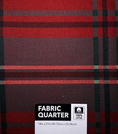 the fabric is red, green and black with a white tag on it that says fabric quarter