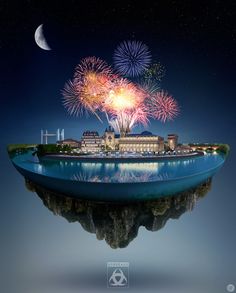 an island with fireworks in the sky and buildings on it's side, as seen from across the water