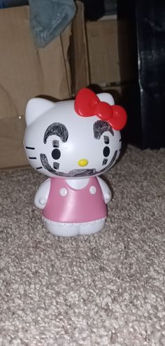 a hello kitty figurine sitting on the floor