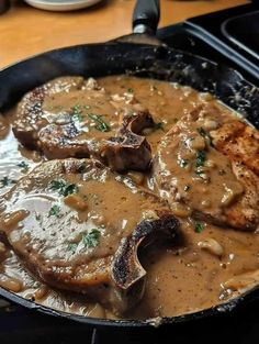 some meat and gravy in a skillet on the stove