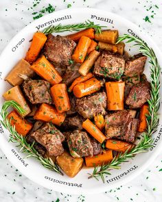 a white bowl filled with carrots and meat on top of a marble countertop