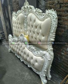 an ornate white couch sitting on top of a cement floor