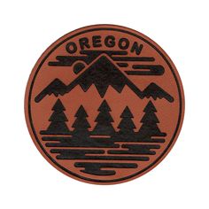 an orange and black patch that says oregon with trees in the mountains behind it on a white background