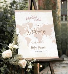 a welcome sign with flowers and greenery