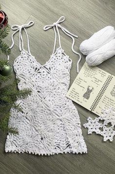 a crocheted dress next to a christmas tree and other items on the floor