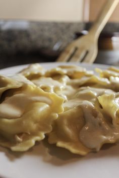 a white plate topped with ravioli covered in cheese