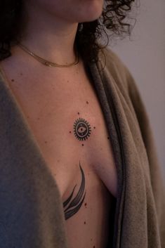 a woman with a sun tattoo on her chest