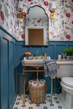 a white toilet sitting next to a bathroom sink under a mirror in a blue room