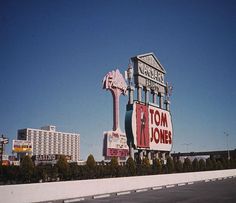 a large sign for the famous tom jones theater in las vegas, nv with tall buildings behind it