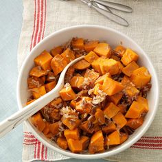 a white bowl filled with lots of food on top of a table