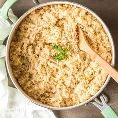 cooked rice in a pot with a wooden spoon and napkin on the side, ready to be eaten