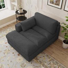 a couch sitting on top of a wooden floor next to a table and potted plant