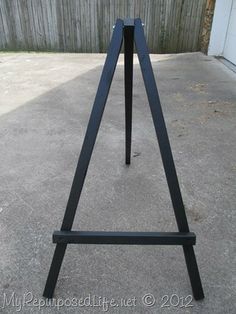 a black metal easel sitting on top of cement