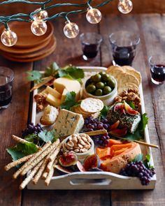 a platter filled with cheese, crackers and olives