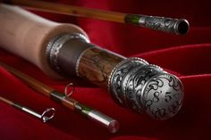 three different types of fishing rods on a red cloth