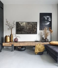 a living room filled with lots of furniture and art on the wall next to a couch