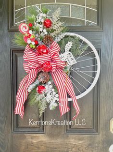 a wreath on the front door of a house with pine cones, berries and candy canes