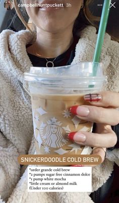 a woman holding a starbucks cold drink in her hand