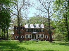 a large red brick house surrounded by trees