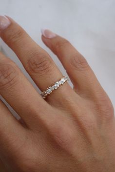 a woman's hand with a diamond ring on top of her left hand,