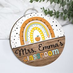 a wooden sign with an apple and rainbow in the center that says, mrs emma's classroom