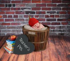 a baby in a basket with a heart shaped sign