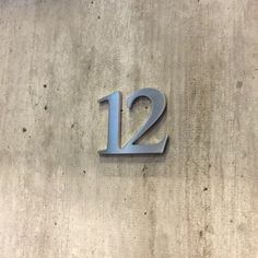 the number twelve is displayed on a concrete wall