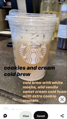 a cup of coffee sitting on top of a counter next to a cookie and cream cold brew