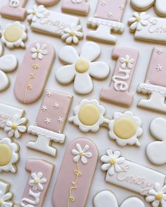 decorated cookies are arranged on top of each other in pastel pink, yellow and white