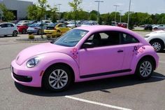 a pink volkswagen beetle parked in a parking lot