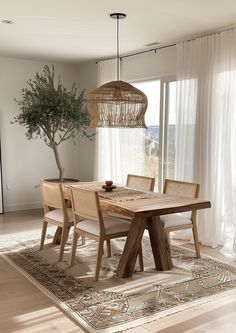 a dining room table with chairs and a potted tree in the middle of it