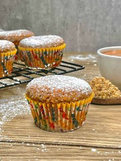 several cupcakes are on a cooling rack with powdered sugar