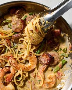 a pan filled with pasta and shrimp on top of a table