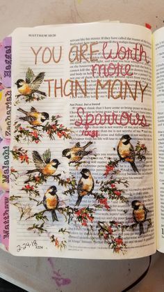 an open book with birds and flowers on it