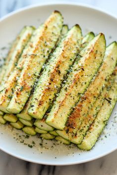 grilled zucchini on a white plate with seasoning